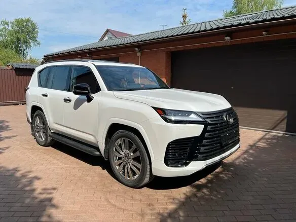 White Lexus LX parked on brick driveway.