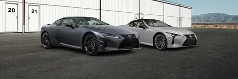 Two Lexus LC cars parked outside garages.