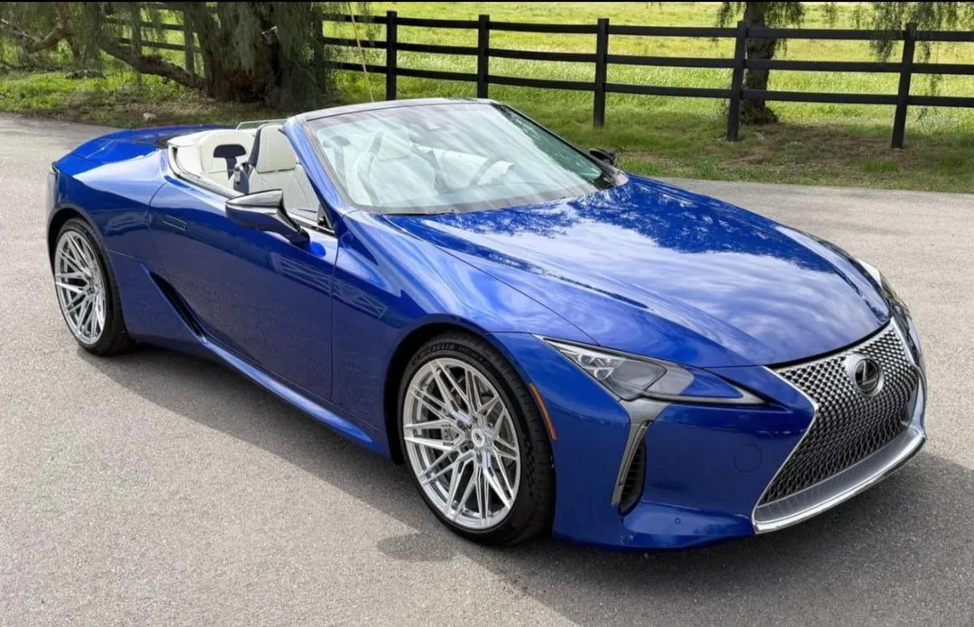 Blue Lexus LC500 convertible parked on road.