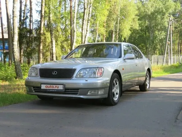 Silver Lexus LS400 parked on a forest road.