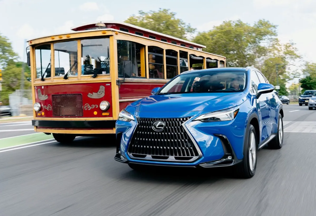 Blue Lexus SUV driving beside a red trolley.